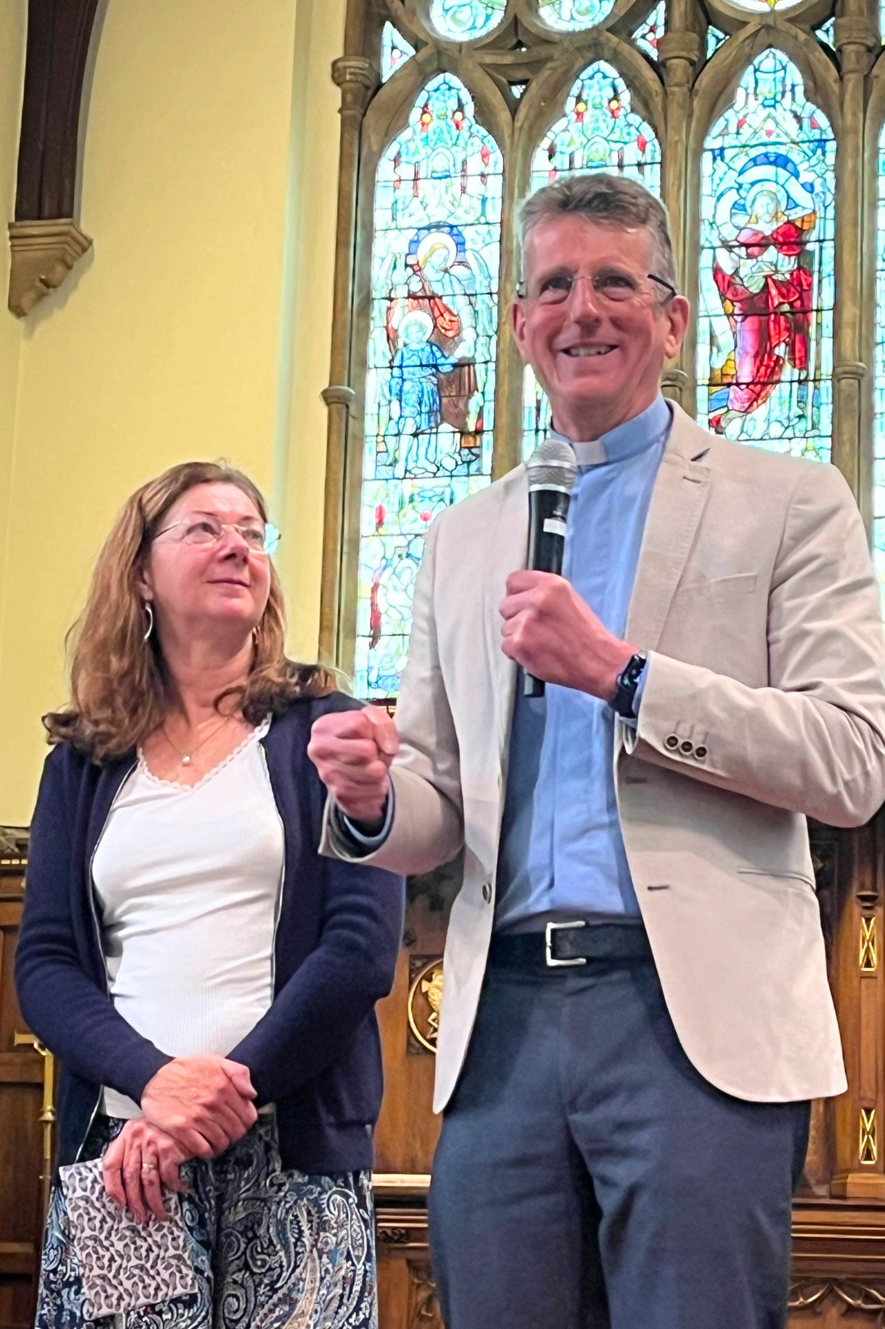 George and Jane Newton standing on the stage at Holy Trinity Aldershot being interviewed