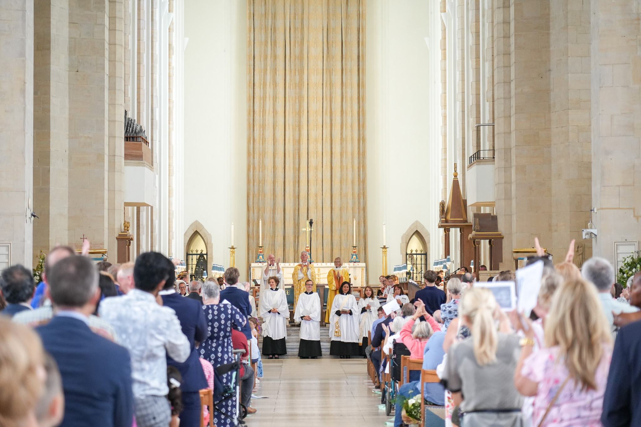 The congregation in the cathedral give the newly ordained deacons a standing ovation as they welcome them as reverends