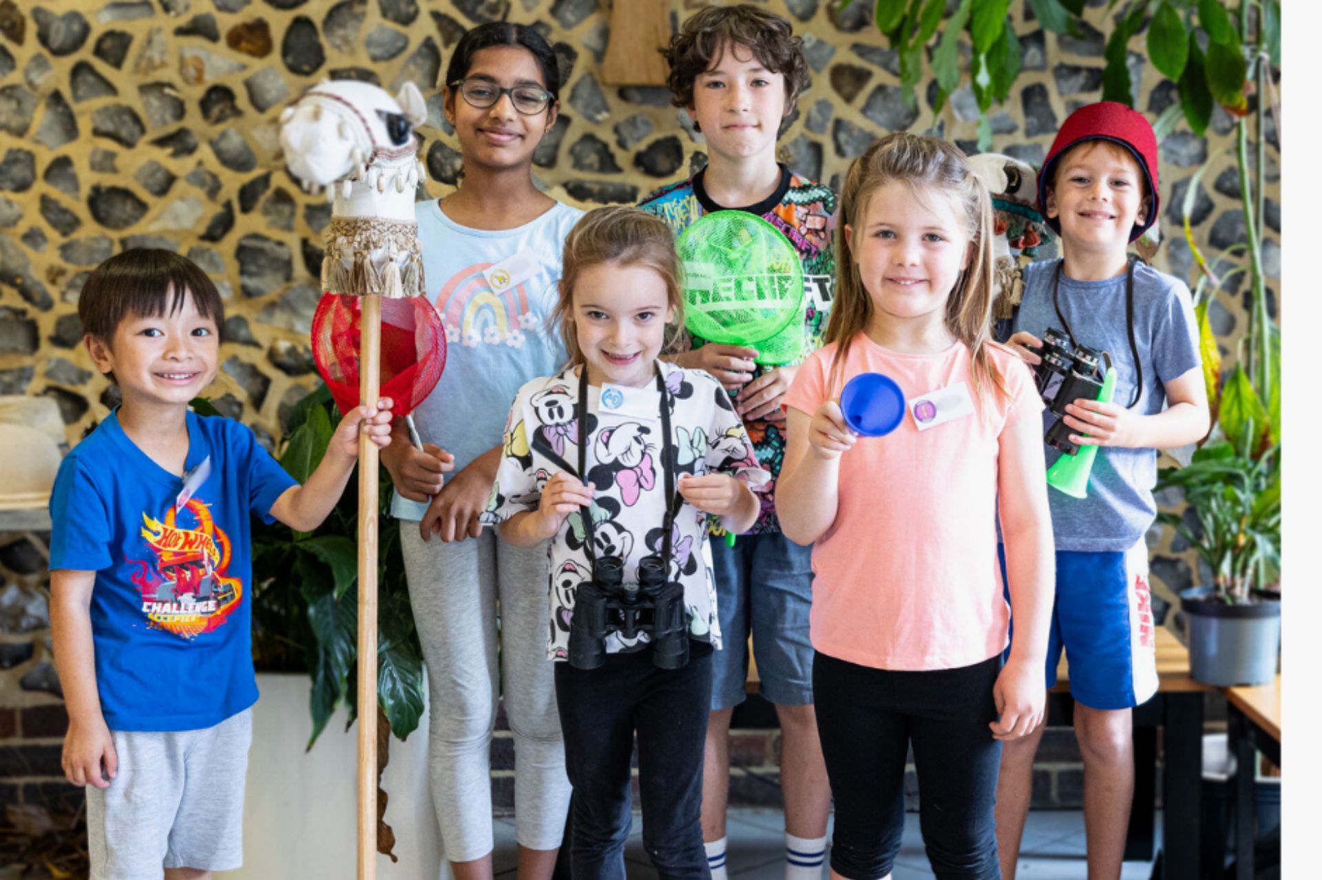 A group of children dressed up as explorers posing and smiling at the camera