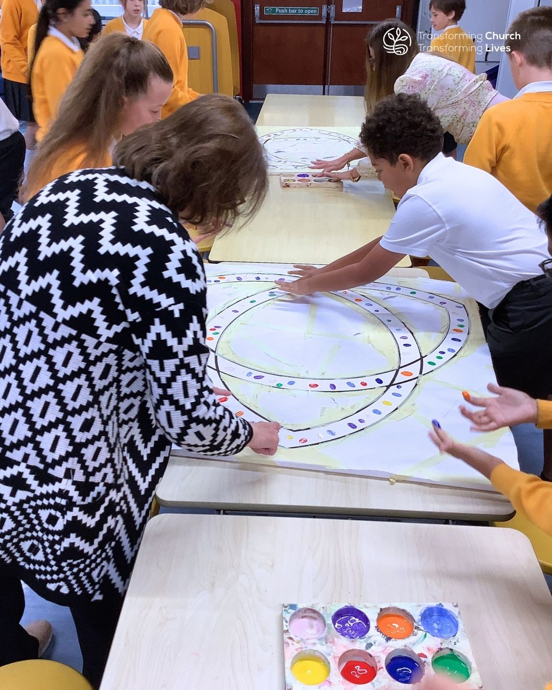 Pupils and teachers add their fingerprints to the canvases using paint