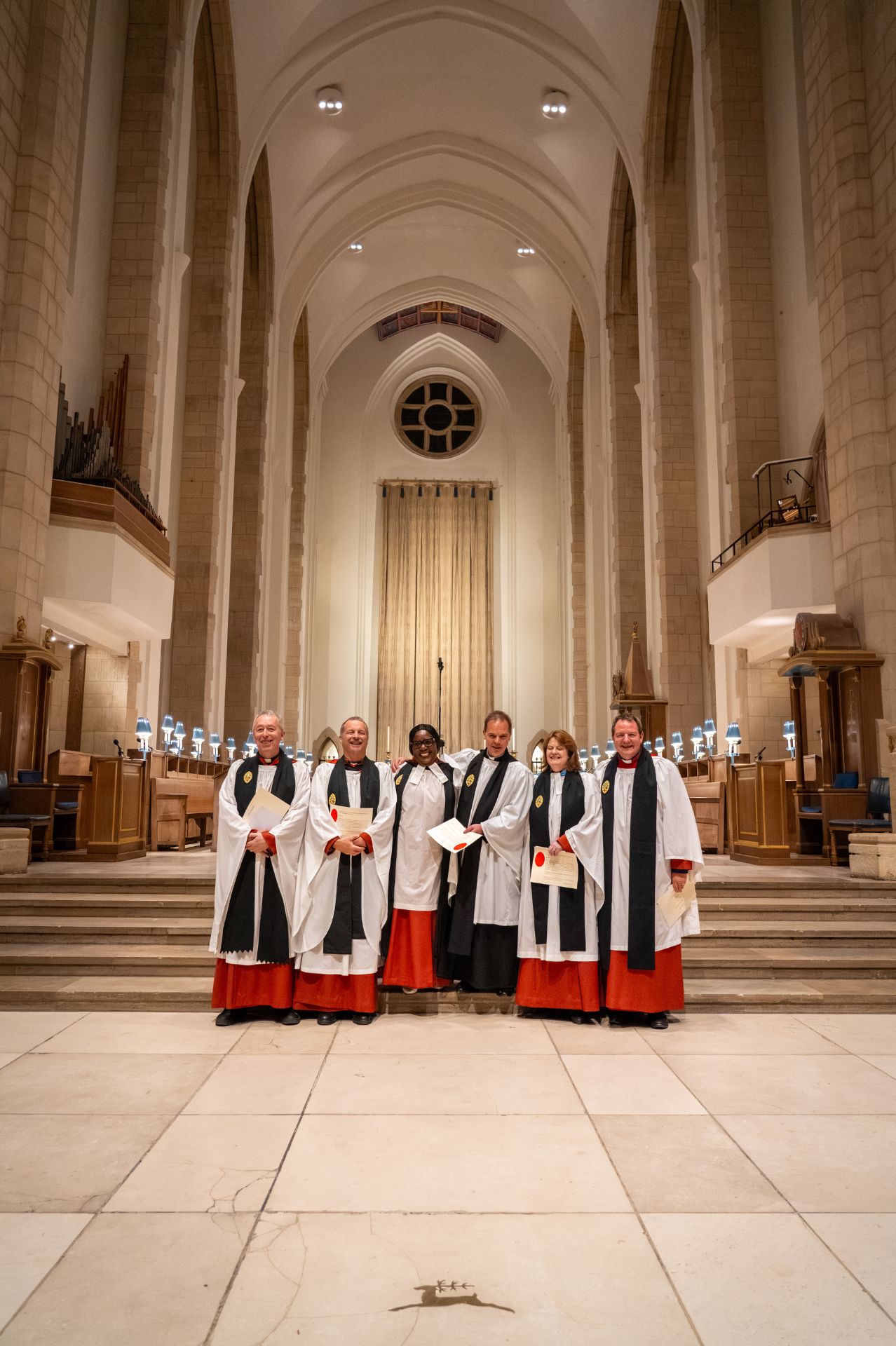 The new clergy Honorary Canons pose for a photo on the Quire steps at Guildford Cathedral