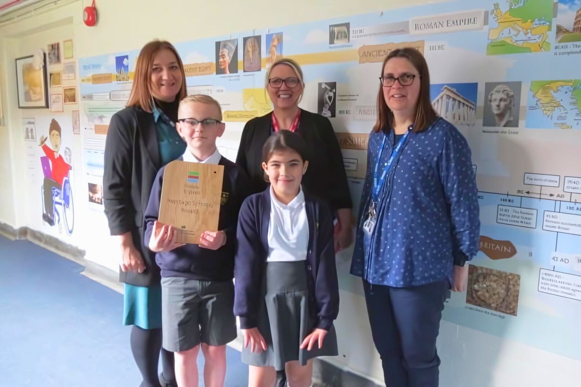 A couple of pupils and teachers pose for a photo with the Heritage Award