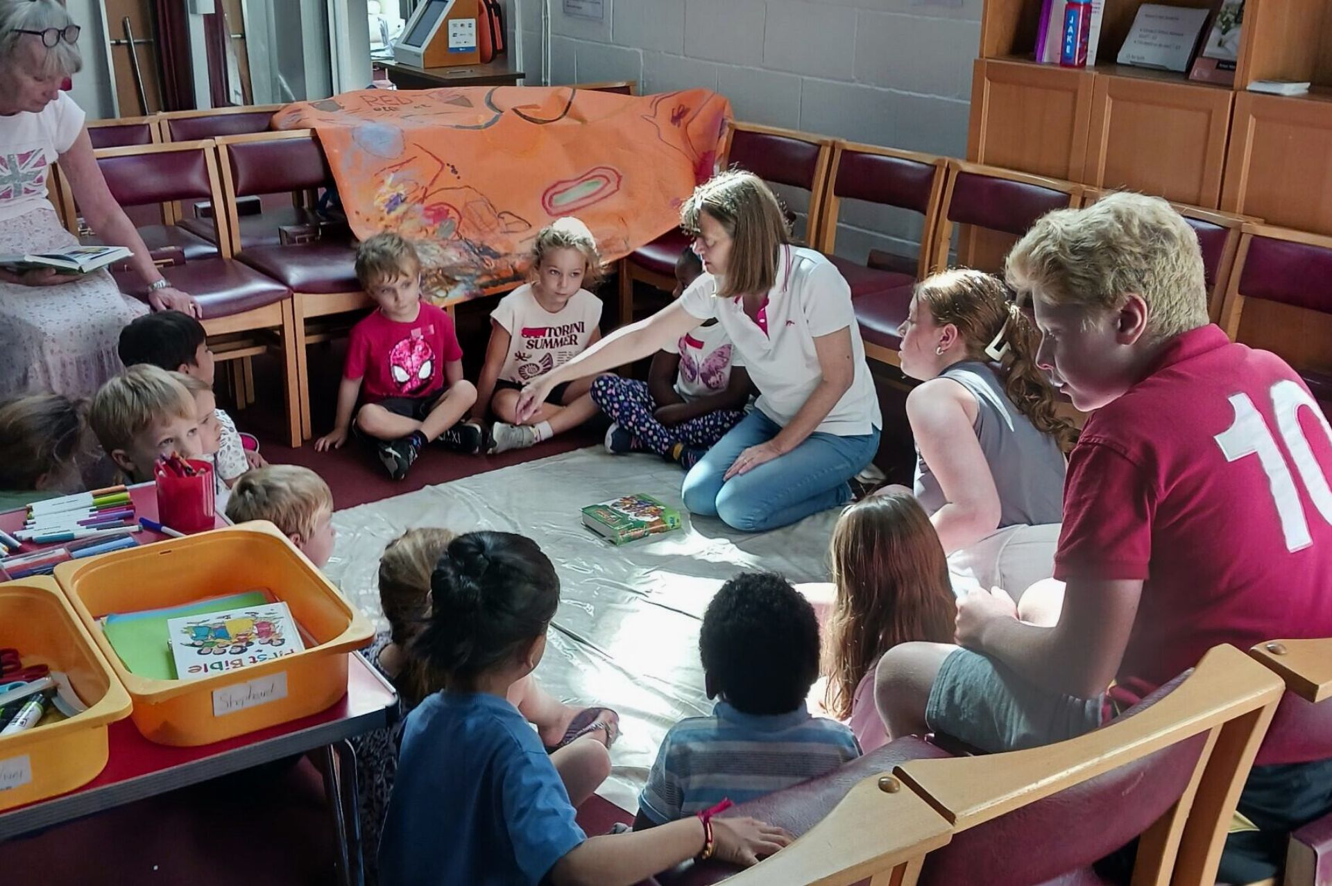 A group of children taking part in an activity with some adult helpers