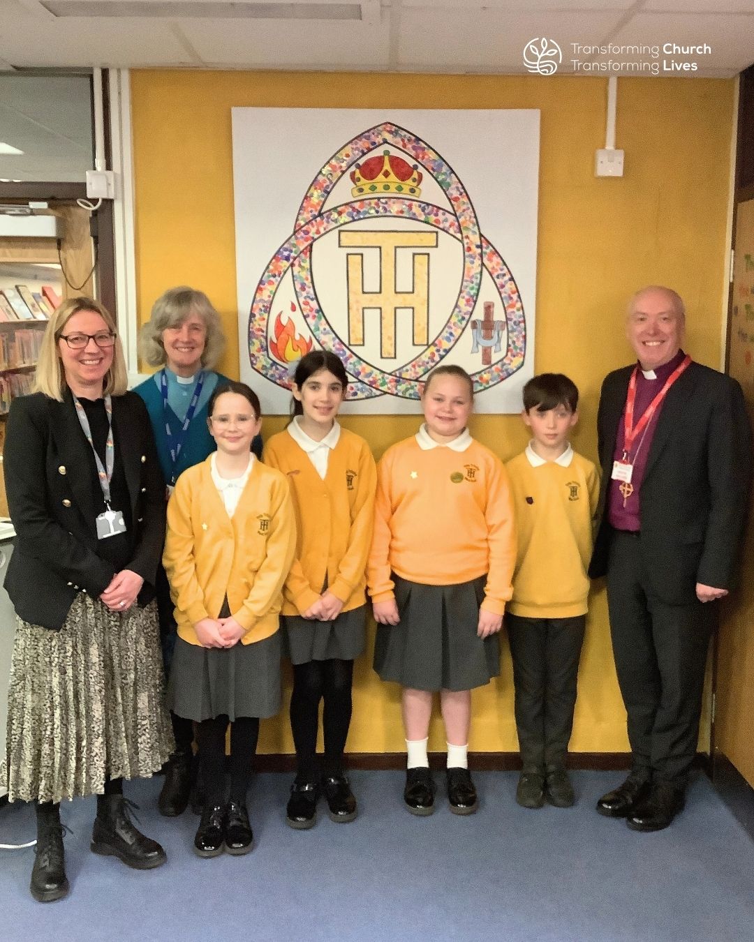 Bishop Paul, Mrs Ambrose, Revd Fiona and pupils pose next to the newly hung artwork