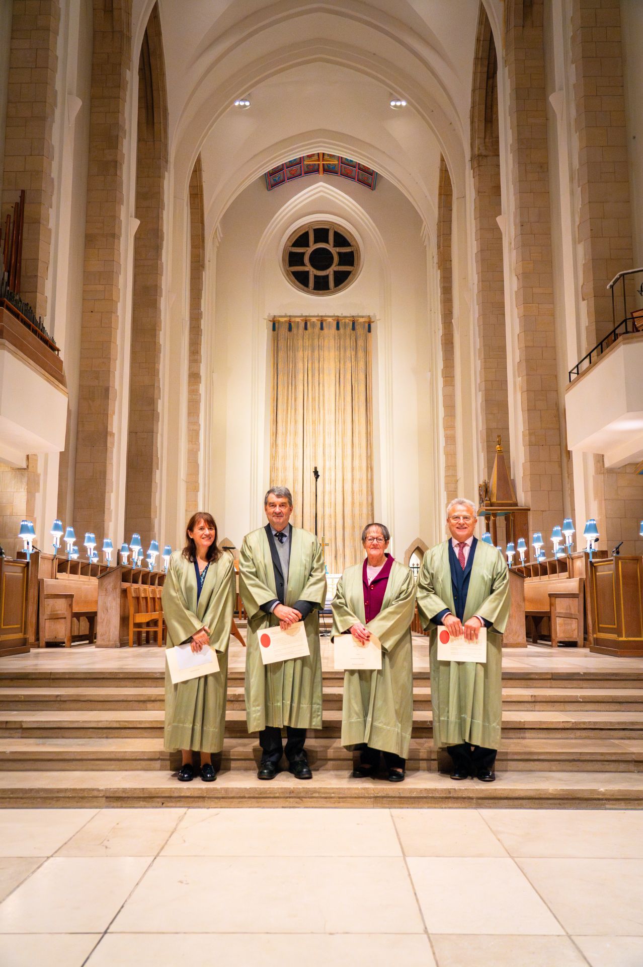 The new lay Honorary Canons pose for a photo on the Quire steps at Guildford Cathedral