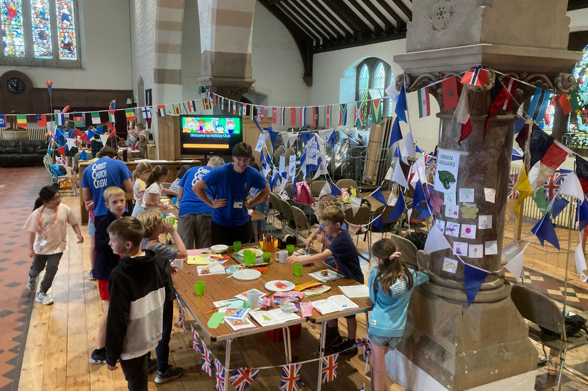 A group of children taking part in crafts at tables inside the church