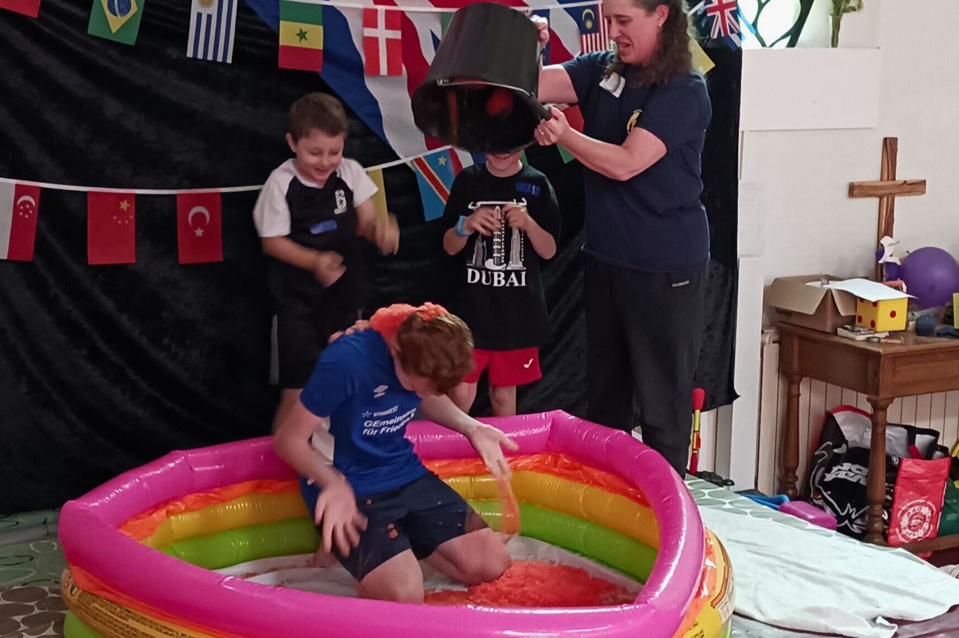 A child being gunged in a paddling pool