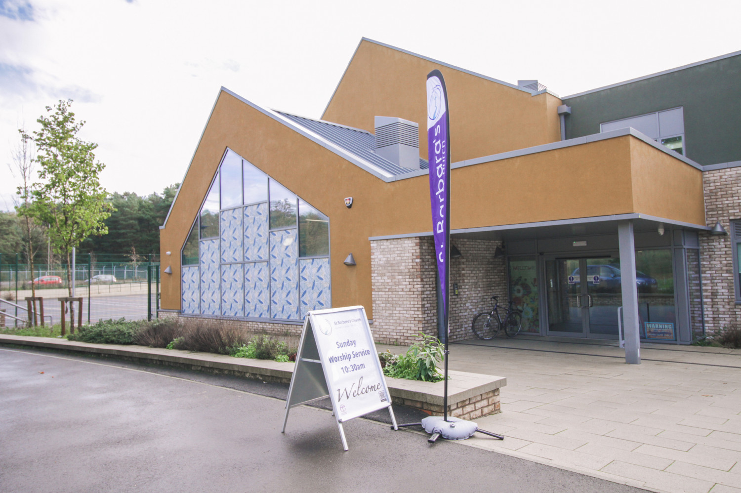 School building with welcome to Sunday worship sign outside