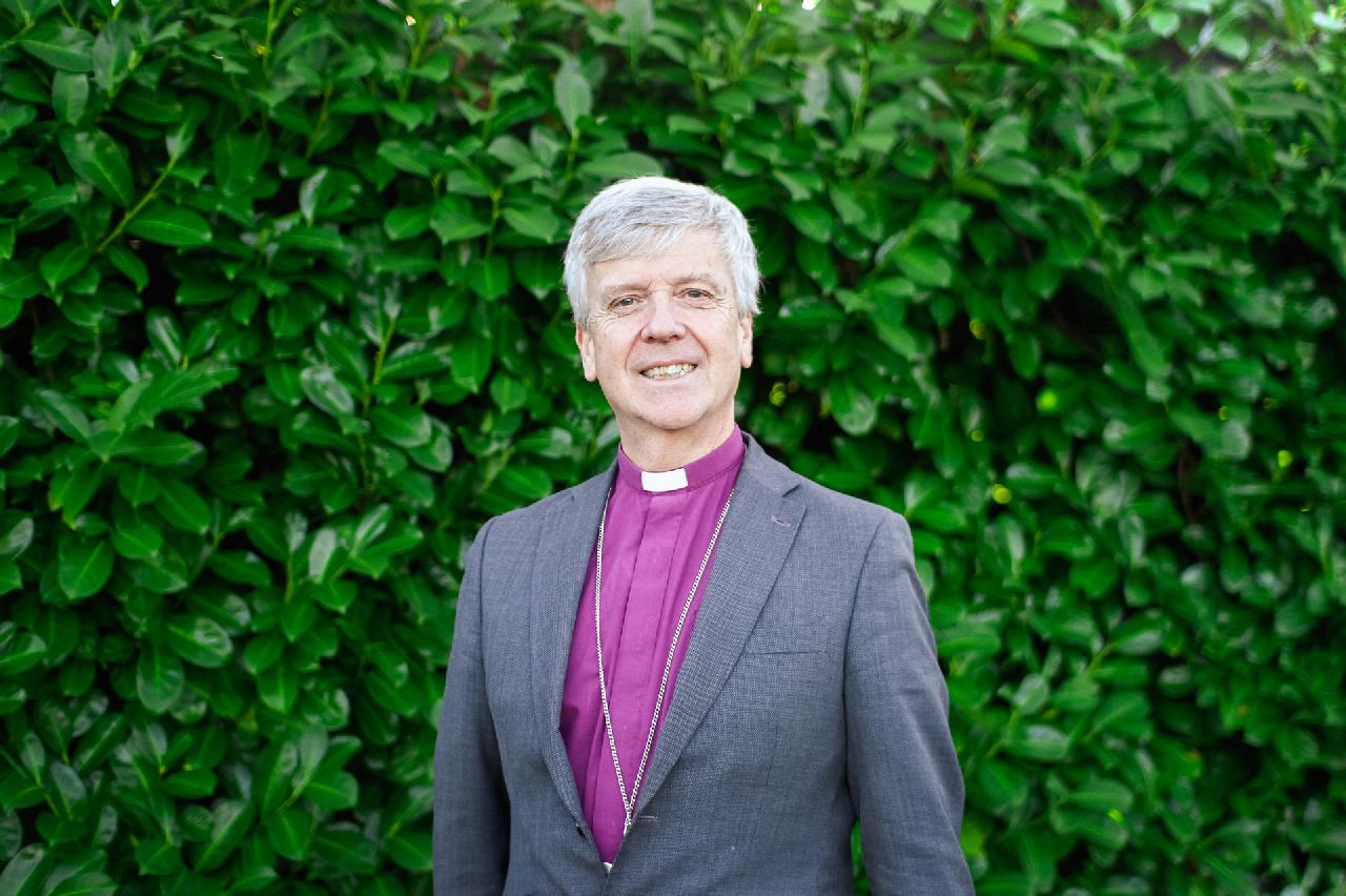 A person in a suit with a priest's collar